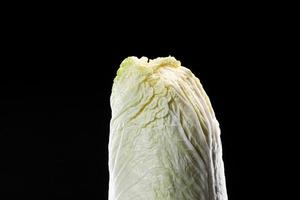 färsk kinakål huvud på svart bakgrund. vegansk mat livsstil. nappakål.kineskål brassica rapa l. , pekinensis grupp foto