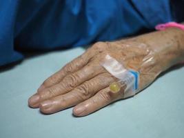 närbild av äldre kvinna hand patienten intagen på sjukhuset foto