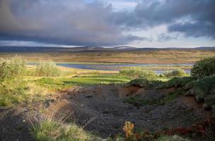fantastiskt landskap med strömmande floder och bäckar med stenar och gräs på Island. foto