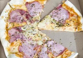 en pizza fylld med skinka foto