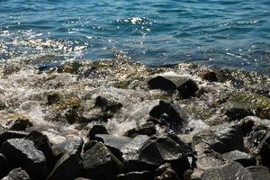 stora svarta stenar på Svarta havets kust med vågor som slår mot dem. landskap foto