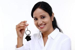 glad affärskvinna innehav hus nyckel foto