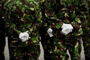 soldater i kamouflaguniform med händerna bakom ryggen