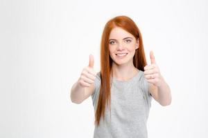 glad rödhårig kvinna visar tummen upp med båda händerna