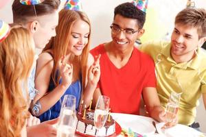 ungdomar firar ett födelsedagssammanträde vid bordet foto