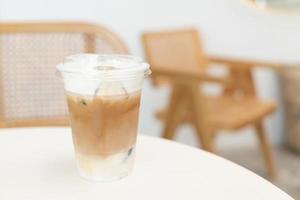 färskt kaffe, iscappuccino, macchiato, latte med separat mjölk och kaffe. kaffe i en plastmugg på ett träbord. plast iskaffe mugg på träbord foto
