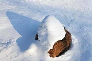 sten under snö foto