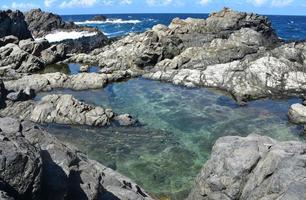 fridfull dold naturlig pool omgiven av lavastenar foto