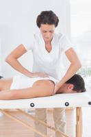fysioterapeut som gör ryggmassage foto