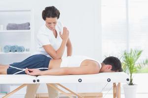 fysioterapeut som gör ryggmassage foto