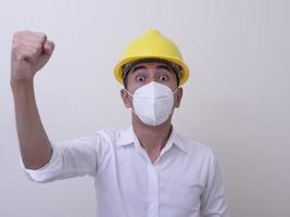 asiatiska industriarbetare bär gula hjälm, bär skyddsmasker för sin hälsa foto