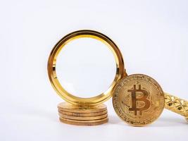gyllene bitcoin replik och förstoringsglas på vit bakgrund. affärs- och finanskoncept. foto