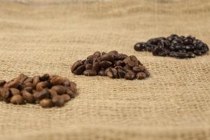 olika rostningskvaliteter av kaffebönor, jutetextilbakgrund foto