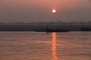 soluppgång på floden ganga, varanasi, indien foto