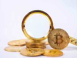 gyllene bitcoin replik och förstoringsglas på vit bakgrund. affärs- och finanskoncept. foto