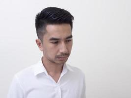 ung asiatisk man isolerad på vit bakgrund tittar i sidled foto