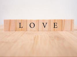 ord kärlek på trä kuber med rött hjärta, närbild nära vit bakgrund valentine koncept foto