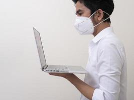 affärsman i medicinsk ansiktsmask fungerar på bärbar dator hemma foto