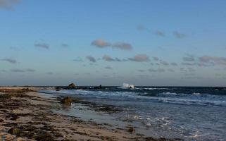 underbar natursköna strand med vågor som slår mot stenar foto