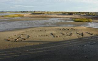 meddelande i sanden gjord av stenar foto