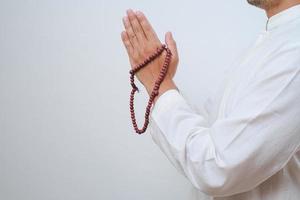 närbild hand som håller en tasbih eller bön pärlor foto