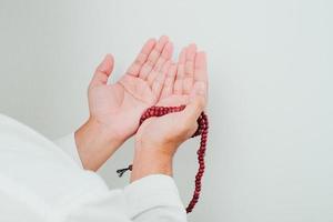 närbild hand som håller en tasbih eller bön pärlor foto