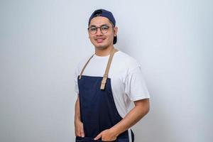 porträtt av ung asiatisk barista leende, bär förkläde foto