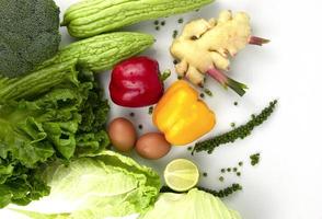 hälsokost med gröna grönsaker på vit bakgrund och naturliga frukter från ekologiska gårdar, med plats för textdesign foto