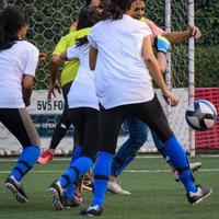 New Delhi, Indien - 1 juli 2018 - kvinnliga fotbollsspelare från det lokala fotbollslaget under match i regionalt derbymästerskap på en dålig fotbollsplan. heta ögonblick av fotbollsmatch på gräs grön fält stadion foto