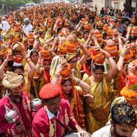 New Delhi, Indien 3 april 2022 - kvinnor med kalash på huvudet under jagannath-templet mangal kalash yatra, indiska hinduistiska hängivna bär jordkrukor som innehåller heligt vatten med en kokosnöt på toppen foto