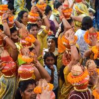 New Delhi, Indien 3 april 2022 - kvinnor med kalash på huvudet under jagannath-templet mangal kalash yatra, indiska hinduistiska hängivna bär jordkrukor som innehåller heligt vatten med en kokosnöt på toppen foto