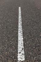 asfalterad väg med vita vägmarkeringar för transportledning foto
