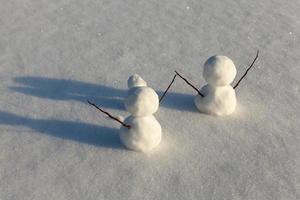 spel i snön med skapandet av flera snögubbefigurer foto