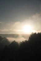 soluppgång med dimma under de tidiga morgontimmarna. foto