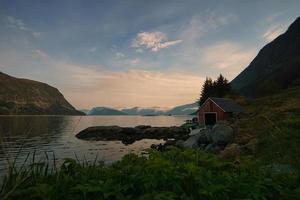 fiskestuga i norge vid fjorden på kvällstimmarna. foto