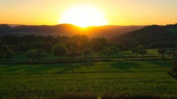 solnedgång i saarland på en äng med träd och utsikt in i dalen foto