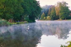 en soluppgång i gryningen, med dimma på floden och varm ljus atmosfär. landskapsbild foto