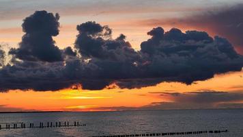 dramatisk solnedgång med regnmoln. färgspektakel på Östersjön i zingst foto