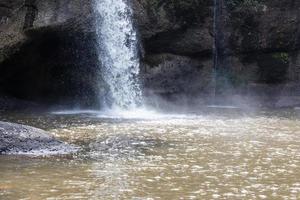 ett naturligt vattenfall i en stor skog mitt i vacker natur. foto