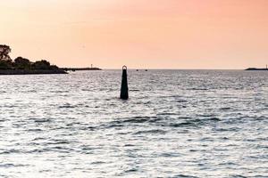 havet solnedgång över piren. vackert havslandskap. drömmar om resor och frihet. bojar till sjöss. solnedgångshimlen och anspråk på väder. foto