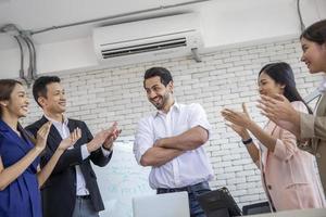 företagsteam som applåderar sin ledare efter framgång på kontoret och diskuterar dokument och idérapporter vid mötet, diskussionsstrategigrupps arbetskoncept foto