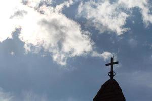 korset högst upp i kyrkan och den vackra blå himlen foto