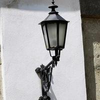 en lampa som hänger från sidan av en byggnad foto