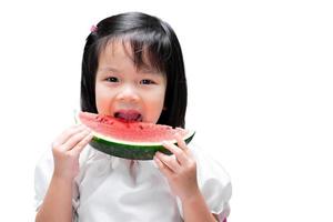 barn flicka med vattenmelon. unge håller röd frukt. njut av att äta stund. isolerade vit bakgrund. barn i åldern 5 år. foto