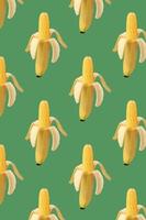 mönster kolv av majs i skalet av banan på grön bakgrund. mat kreativa koncept. fotomanipulation med banan. konst koncept. färgglada fruktmönster. tropisk abstrakt bakgrund. foto