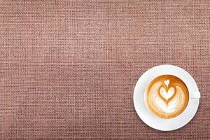ovanifrån latte art kaffe på bomullstyg bakgrund foto