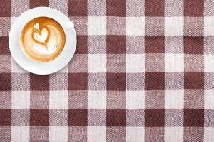 ovanifrån latte art kaffe på tyg textil textur bakgrund foto