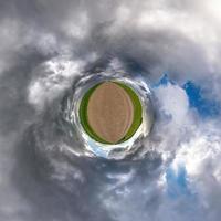 liten planet i blå himmel med sol och vackra moln. transformation av sfäriskt panorama 360 grader. sfärisk abstrakt flygfoto. utrymmets krökning. foto