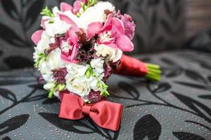 brudbukett av vita och rosa pioner och rosor med knytrosett foto