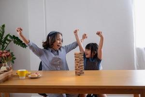 mormor och barnbarn spelar spel. blockwood pussel för att utveckla färdigheter för barnbarn och som en semesteraktivitet foto